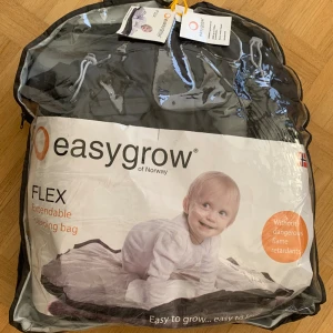 Easygrow Flex Extendable åkpåse mörkgrå - Nyskick, utan slitage eller fläckar. Vindtät & vindtät. Öppningar baktill för att fästa i barnvagnen. Inkl förlängning. 98cm utan och 130cm med förlängning.