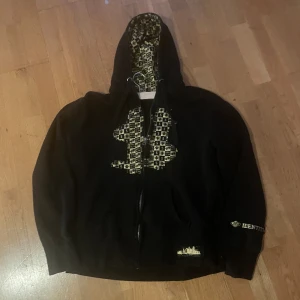 Y2k hoodie  - Fet hoodie med guldigt print, står L men passar mer m