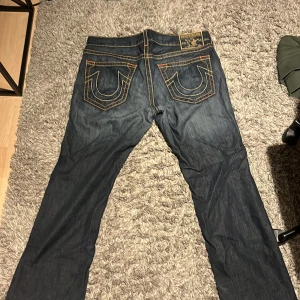 Vida True Religion jeans - Feta True Religion jeans med snygg fade. Jeanses är äkta och i bra kvalité, dock små slitningar men ingen som gör byxorna fulare enligt mig (kontakta mig för bilder) strl. 38 W 33-34L