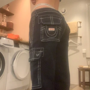 True Religion Jeans X Urban Outfitters  - Mörkblåa True Religion jeans med vita sömmar. Storlek 27 säljer för att det var ett impulsköp och dom är förstora för mig så har aldrig använt dom. Dom är alltså helt nya💞En exklusiv collab med Urban Outfitters så finns nog inte längre att köpa.