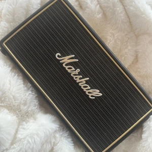 Marshall högtalare  - Bluetooth högalare från Marshall ”Stockwell”. Köpt för flera år sedan, säljs inte längre.  Texten och siffrorna något utsuddade (volume, bass, treble).  Laddare medföljer. Ljudet fungerar som det ska. Nypris 2500kr.