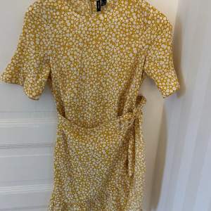 Gulblommig klänning från vero moda med omlott detalj. Använd en gång 
