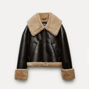 SLUTSÅLD SKINNJACKA ZARA PRISLAPP KVAR - Helt oanvänd, prislapp kvar.   Slutsåld brun jacka från Zara.  Bikerjacka i skinnimitation. Kombinerat teddyfoder på insidan i kontrast. Krage med vida och justerbara slag. Hälla. Långärmad. Uppvikta ärmslut. Framfickor.   Liknande Filippzors :)