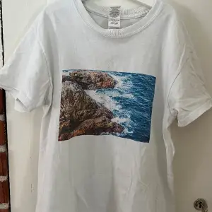 En t-shirt i tjock bomull från märket the cool elephant med ett tryck på havet, storlek s, på trycket syns det lite att den har blivit tvättad några gånger men annars väldigt fint skick 