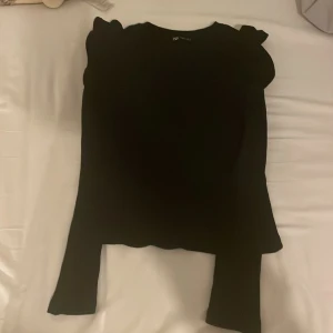 Svart långärmad tröja - Svart långärmad med volanger uppe vid axlarna. Använd typ 2 gånger.