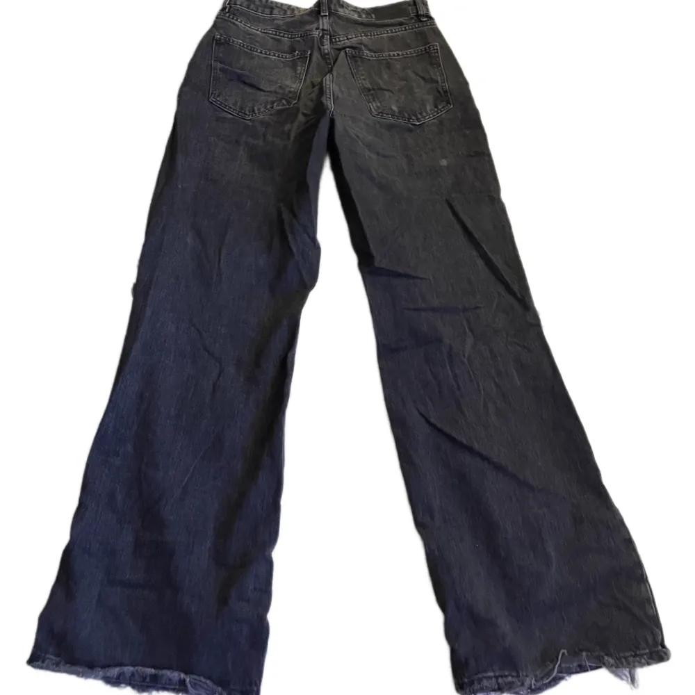 svarta highwaist vida jeans med stora hål! liten fläck bak på låret. strl. 40 från gina tricot! använda, relativt bra skick. Jeans & Byxor.