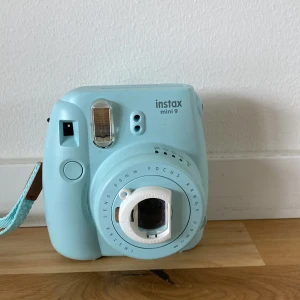  Kamera  - Det är en kamra som du tar bild med och sedan kommer det ut en bild. Du måste köpa bilderna i en affär och sedan lägga in i kamran. Det blir färger på bilderna när du tar bild. 