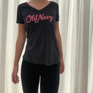 T-shirt från Old Navy - Superskön mörkgrå T-shirt med rosa tryck, köpt från Old Navy. Använd men i bra skick! 