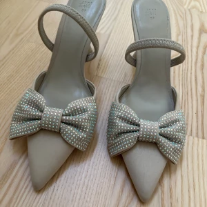 Klackskor  - Jättesnygga klackskor, perfekta för balen, med rosetter från HM i storlek 39💕 Helt i nyskick och oanvända!🥰 säljer då dom var lite för stora! Skriv privat vid frågor.  Dom är beige/grå. Mest grå 