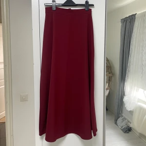 Långkjol - nyskick - Lång vinröd kjol, använd 1-2 gånger. Mycket skön och har en bra kvalite. Har en dragkedja på bakdelen. Priset kan diskuteras.