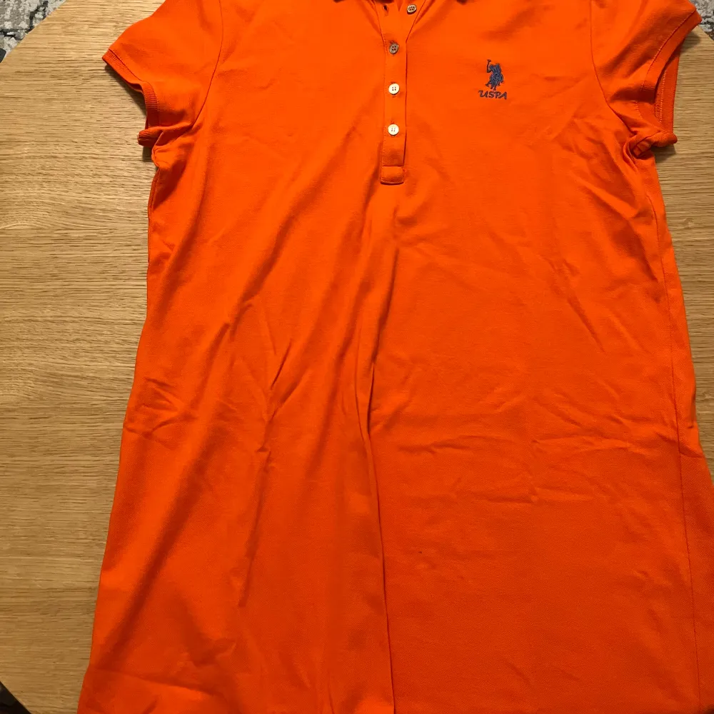 Orange polo klänning i storlek L. Använd ett par gånger. Säljer pga att den inte kommer till användning. . Klänningar.