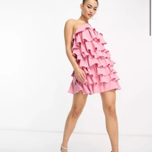 Rosa volangklänning - Säljer denna supersöta festliga klänning då den inte kommit till så mycket användning. Använd endast en gång, så den är i princip i nyskick. Hör av er  för fler bilder på den🩷 priset ligger på 650kr inklusive frakt. Köpt för 790kr