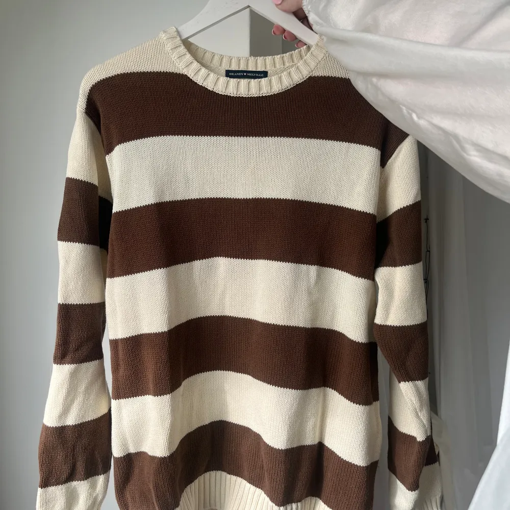 En brun/beige stickad Brianna sweater ifrån brandy melville! Superfin och i bra skick! Säljs då den inte kommit till användning. ❤️. Stickat.