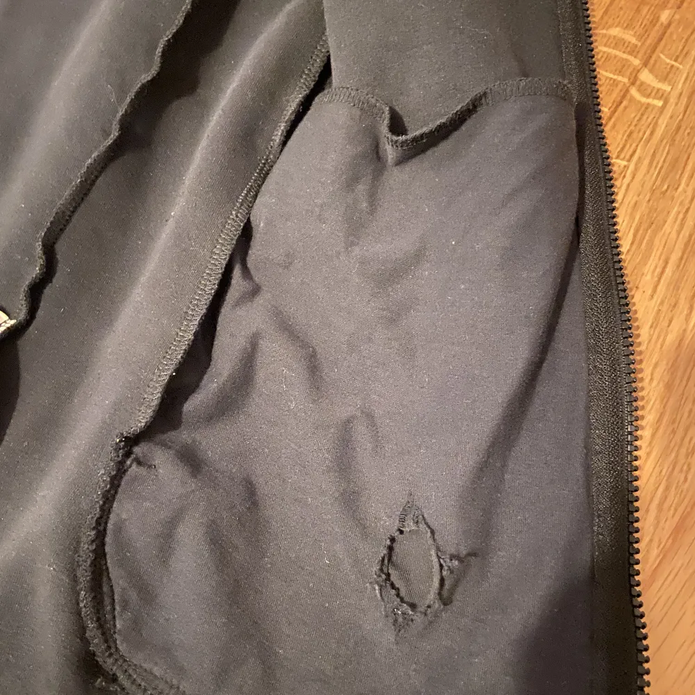 Hål i fickan som ej syns och fickan går ändå att använda, hål i luvan som ej syns och knopprig men syns inte eftersom tröjan e svart.. Hoodies.