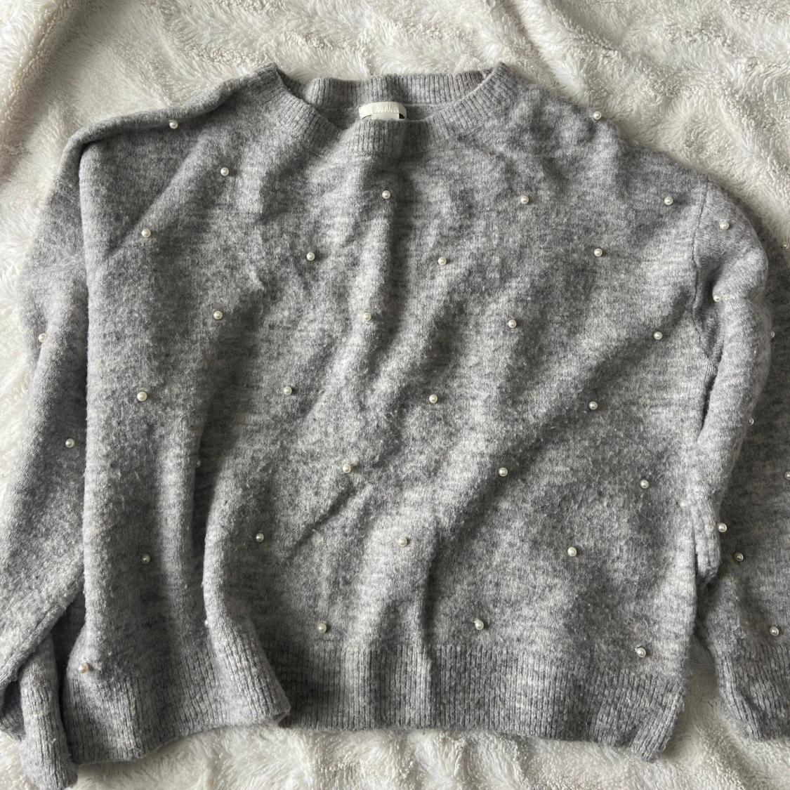 Stickad tröja med pärlor