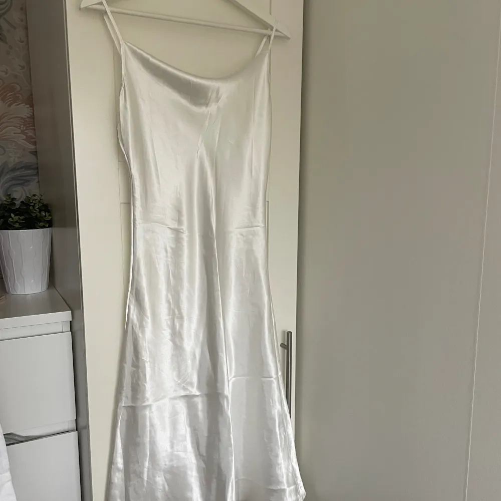 Vit Satinklänning i knälängd. Storlek S. Köpt via tise, aldrig använd. . Mekot.