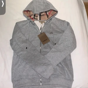Burberry - De är en zip Hoodie slm kostar runt 4000kr ny, har tröttnat på den och vill ha nått nytt, den är typ i nyskick o inga skador på den. Färgen ser konstig ut på bilde. Den ser mörkare ut än vad en är men den är ganska ljus i verkligheten. Går att pruta