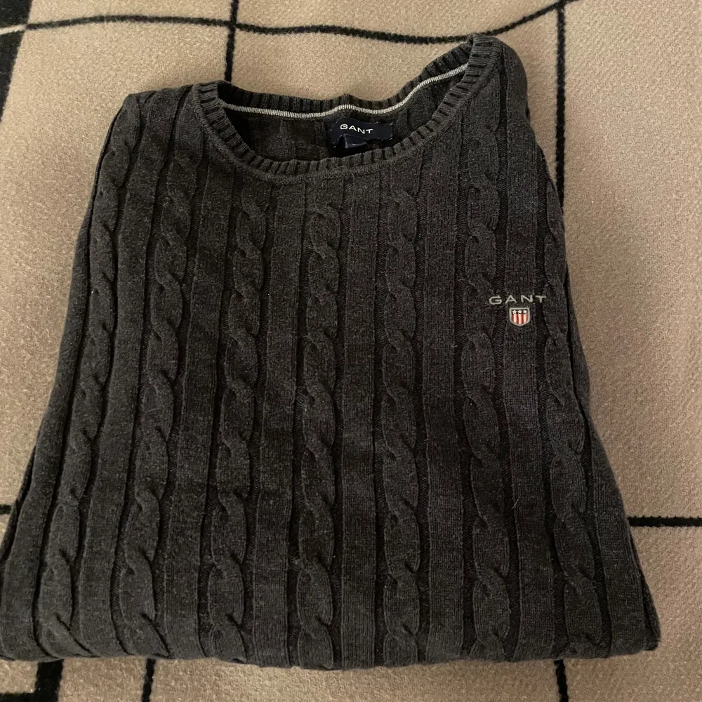 En stickad mörkgrå tröja från gant. Storlek XL men känns som en stor M. Använd men i bra skick.. Tröjor & Koftor.