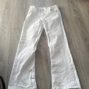 Ett par vita jeans som kommer från Gina med fickor där bak.