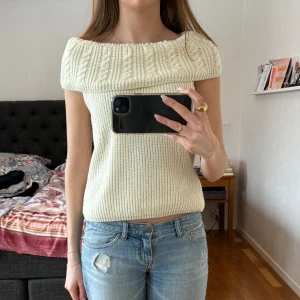 Off sholuder topp - Stickad off shoulder tröja i vit/creme färg med silvertrådar som glittrar, lite svårt att se på bilden. Mönstrad halsringning. Skulle säga att det är storlek S.