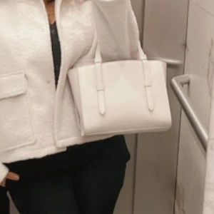 Dam väska - Säljer denna super snygga créme vita/beiga väska. Köpt från zara, minns inte pris riktigt men runt 359-379kr. Säljer för 250kr. Använt väldigt fåtal gånger. 1-3 gånger. Super snygg väska!!!!! Å bra med plats och utrymme.  