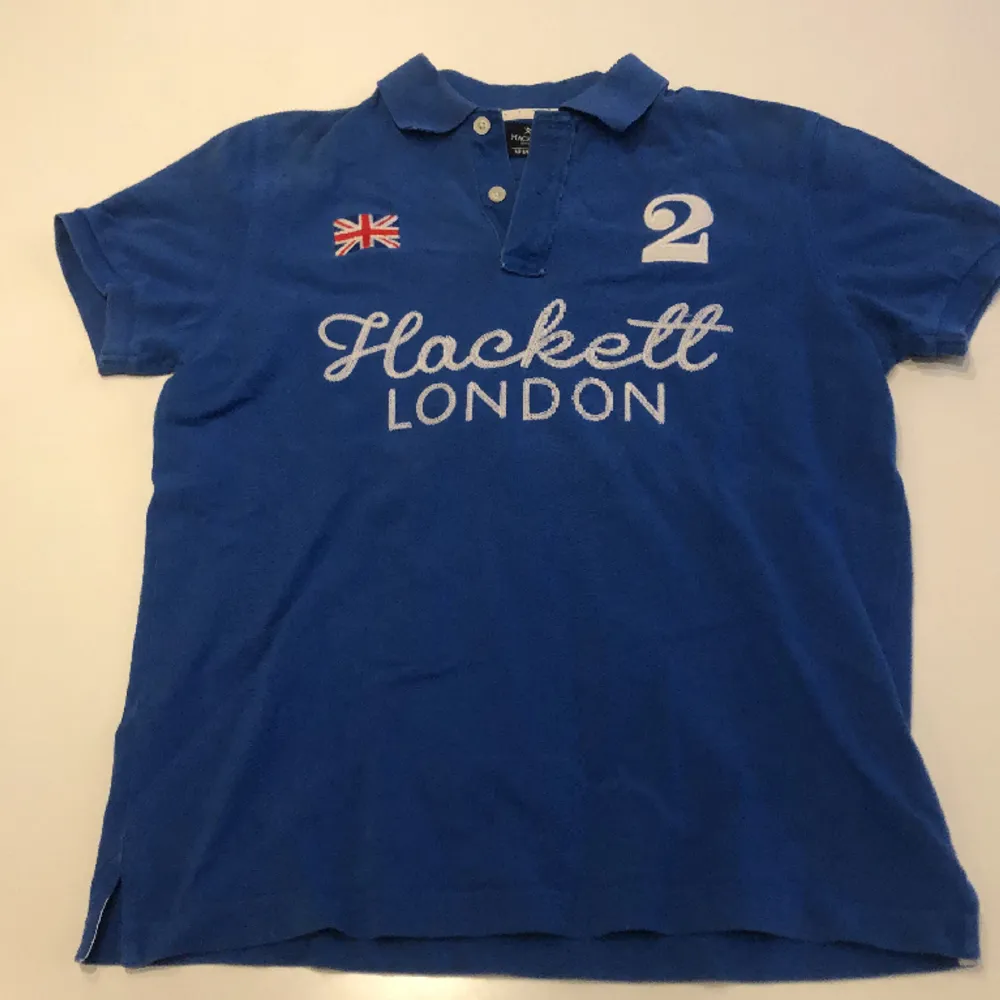 Pikétröja från Hackett med små slitningar längst kragen som visas på sista bilden. . T-shirts.