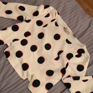 Supersöt topp - Gullig topp med svarta prickar och röda detaljer. Lite knoppning på ärmarna. 