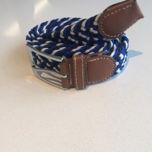 Flätat bälte blå vit  - Flätat bälte ljusblå mörkblå vit | stretch och anpassningsbar till alla storlekar | helt nytt aldrig använt | skriv om du har frågor. 