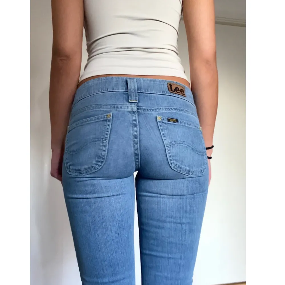 Säljer nu mina supersnygga ljusblå lågmidjade bootcut jeans från märket Lee. Storleken på etiketten är W26 L33 och de sitter perfekt på mig som är cirka 167cm lång.   Midja: 36-38cm  Innerbenslängd: 82cm  Hör av dig för fler bilder och mått!. Jeans & Byxor.