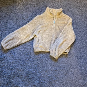 Fluffig tröja - Gosig tröja i teddybjörn-tyg men hög krage och dragkedja i halsen. 