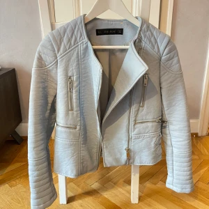 Ljusblå skinnjacka från Zara - Jättefin jacka i strl S. Använd fåtal gånger och i fint skick. Lite avskalat material i kragen vid lappen men inget som kommer synas vid användning. 