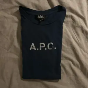 Mörkblå APC Tshirt i extremt bra skick! Inga defekter överhuvudtaget (textens slitning är del av designen). Nypris ligger på runt tusenlappen. Säljes då den inte passar mig.