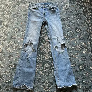 Regular waist bootcut jeans med hål och slitningar! Midjemått tvärsöver: 34. Innerbenslängd: 78 cm.