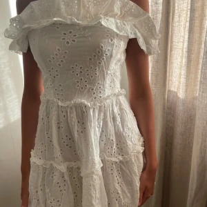 Vit sommarklänning -  Vävd, broderad kvalitet - Off shoulder-design - Knapp - Markerad midja - Smock i ryggen - Totallängd i strl S: 77 cm Nypris 899, använd endast 1 gång