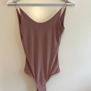 Somrig topp - En väldigt fin somrig stringbody med väldigt skön material. Figurnära passform. Bra skick