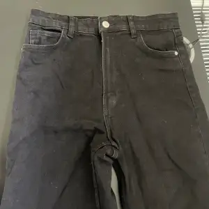 Ett par supersnygga gråsvarta jeans som endast är provade, så i princip helt nya! De är raka i modellen med slitsen ger lite av en flare effekt! Gör sig supersnygga till både klackar och sneakers