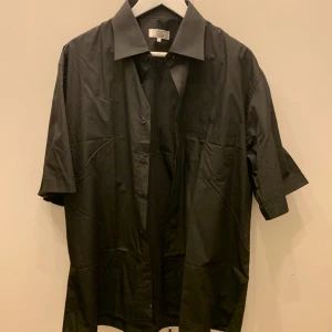 Kortärmad Skjorta - Kortärmad Svart skjorta säljes, Aldrig använd, Storlek XL (B45/L75).