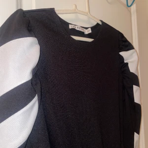 Svartvit klänning  - Svart klänning med snygga detaljerade ärmar. Skärpet är ej med. Storlek XXS/XS. Från IVYREVEL. Använd en gång. Mycket bra skick! 