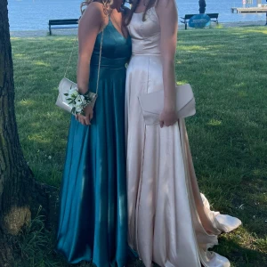 Balklänning - Underbar balklänning från YouMeFashion köpt 2021. Endast använd under en kväll och är försiktigt tvättad efter användning. I satinmaterial i en jättefin champange-rosa färg😍Öppen rygg med så charmig snörning och lite släp i kjolen. Köpt för 2890kr!!