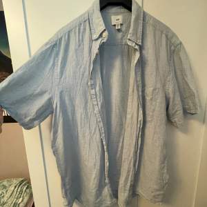 Somrig ljusblå linneskjorta i storlek M från H&M. Använd någon enstaka gång, annars så gott som ny.