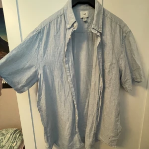 Ljusblå linneskjorta  - Somrig ljusblå linneskjorta i storlek M från H&M. Använd någon enstaka gång, annars så gott som ny.