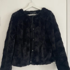 Svart pälsjacka Vero Moda - Svart pälsjacka från Vero Moda. Står ingen storlek men den passar mig som är storlek 36-38. Knappt använd så i princip nyskick. Superfluffigt och mjukt material (fuskpäls) 🧸 