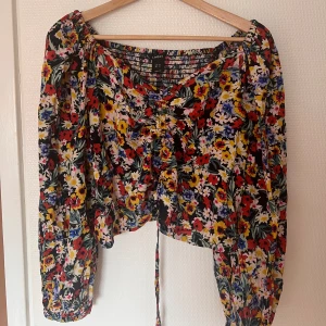 Sommartopp i nyskick - Jättefin blommig sommartopp från Lindex. I Stl XL men är liten i storleken. Snörning framtill som gör att längden är justerbar. Luftiga armar och bekväm passform. 💓