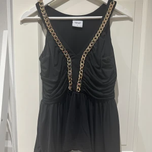Linne med kedja - Svart linne med guldig kedja. Använd fåtal gånger. 
