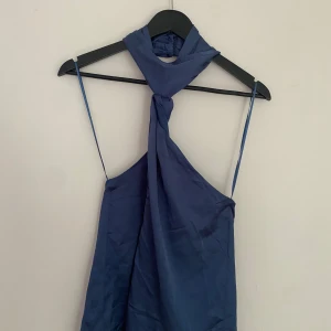 Blå halternecktopp - Använd en gång. Väldigt låg i ryggen och ganska stor för mig som vanligtvis har storlek M.