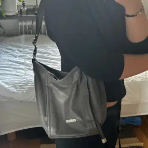 Skit snygg grå väska från Kappahl! Har knutit upp banden så den går att få längre. Den har fack, mycket plats och super snygg!