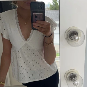 Söt sommartopp - Vit v-ringad topp utan ärmar, perfekt till sommaren!