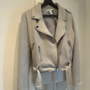 Biker jacket NLY - Biker jacket grå strl 34 Från NLY trend. Är i gott skick trots väl använd. Perfekt nu till våren!