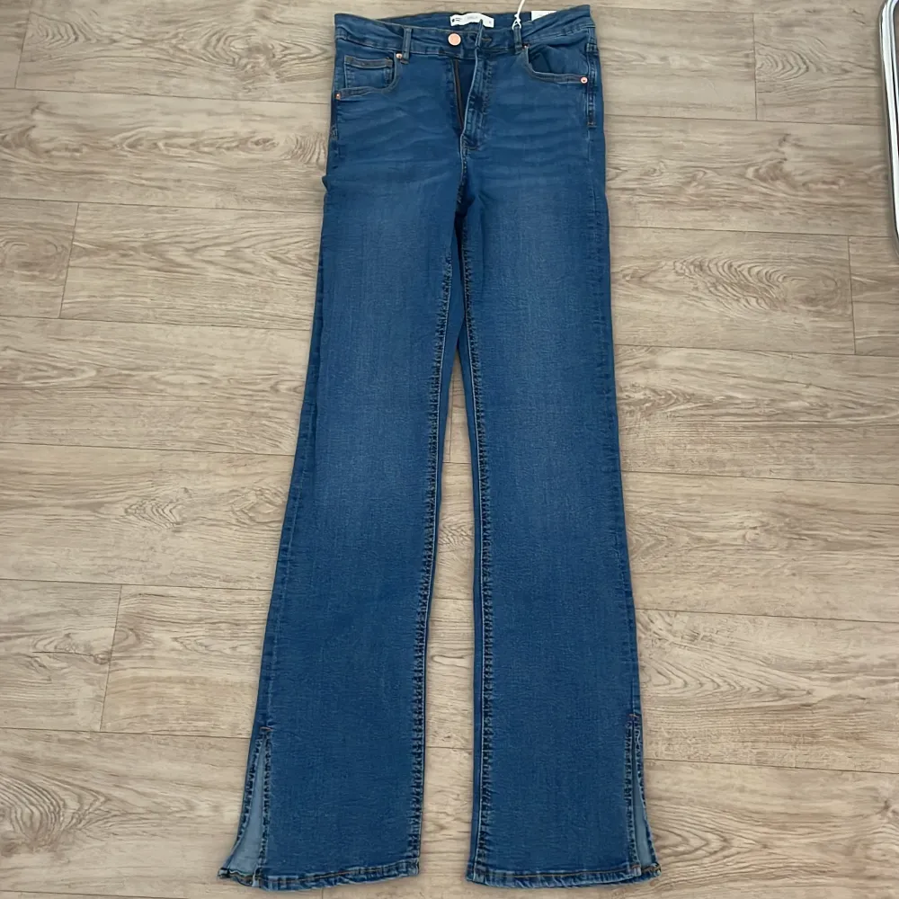 Helt nya blåa jeans med slit från Gina Tricot. Har aldrig används och är i storlek M.. Jeans & Byxor.