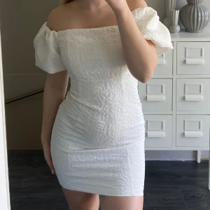 Vit klänning/studentklänning - Vit klänning ifrån bubbleroom i storlek 34. Köpt förra året och endast använd 1 gång på studentmottagning. Jättefin passform som följer kroppen. 